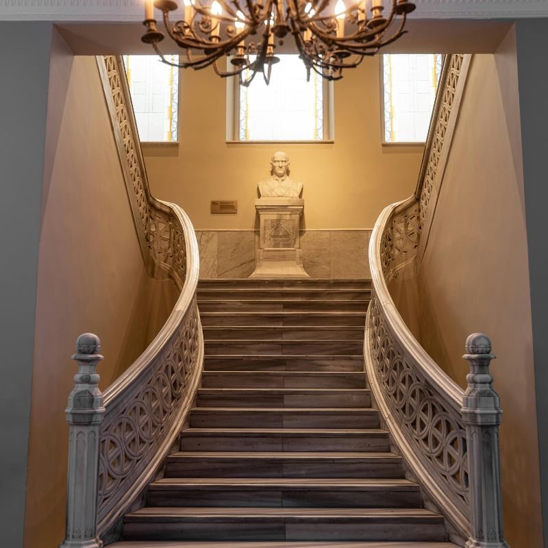 Escalera de mármol en residencia de alta gama en Nueva Inglaterra gestionada por Luisita Pumphrey Real Estate Advisor.